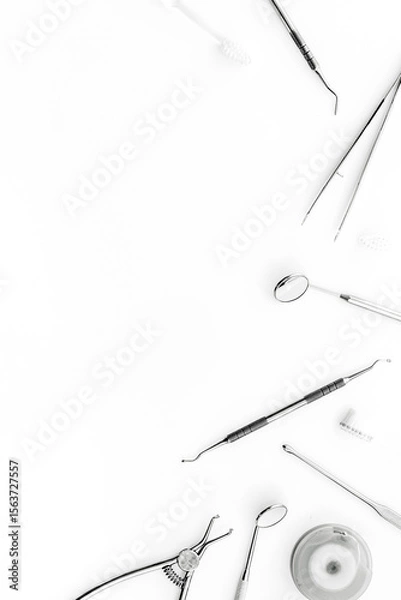 Obraz Stomatological tools on dentist's desk on white background top-down frame copy space
