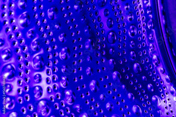 Obraz Empty washing machine drum inside in blue light, closeup view. Metal dots and bubbles as abstraction and background
