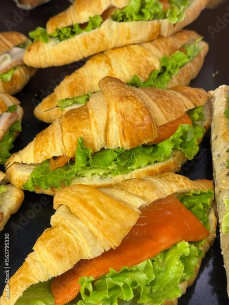 Obraz Freshly made croissant sandwiches with lettuce and salmon. Ideal image for café menus, breakfast, or healthy snack themes