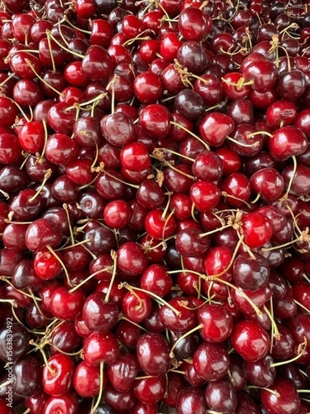 Fototapeta eap of fresh sweet cherries with stems. Rich red tones and glossy texture make them visually appetizing