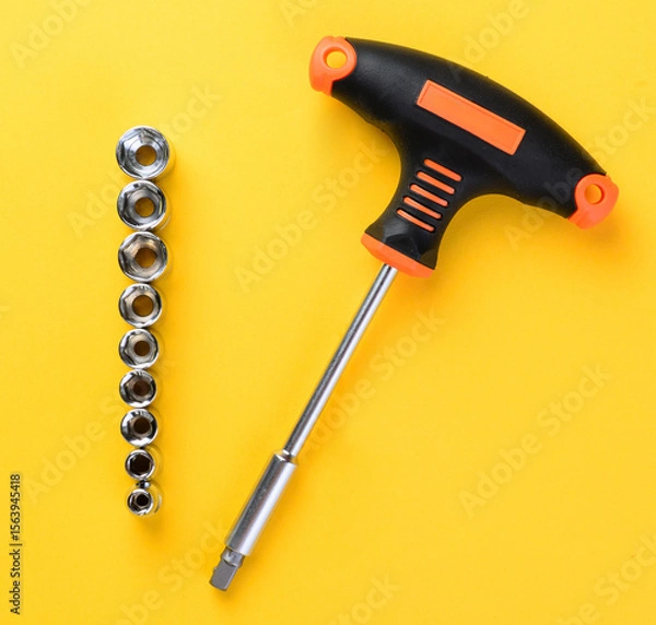Fototapeta Socket holder with sockets arranged on bright yellow background top view metal tools set