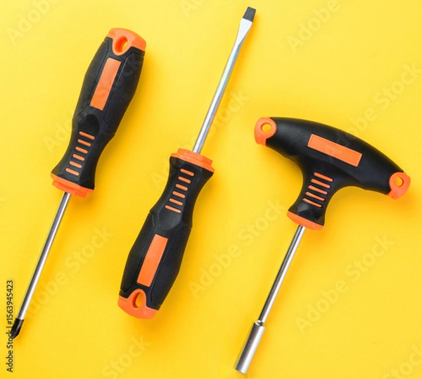 Fototapeta Screwdrivers and bit holder set on bright yellow background top view flat layout
