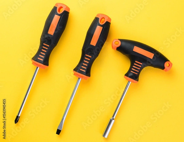 Fototapeta Screwdrivers and bit holder set on bright yellow background top view flat layout