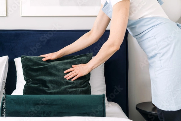 Obraz Neatly arranging decorative cushions in a modern hotel bedroom setting