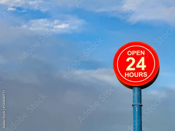 Obraz Open 24 hours sign isolated against a blue sky. No people. Copy space.