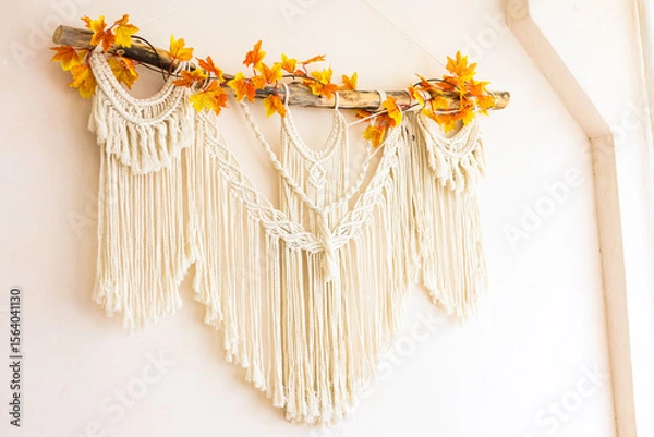 Obraz Macrame wall hanging decorated with autumn leaves in a cozy indoor setting