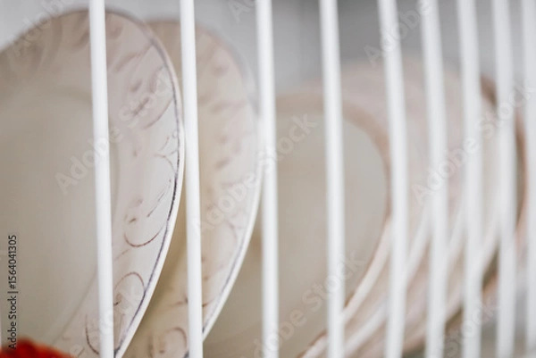 Obraz Colorful plates drying in a dish rack after washing