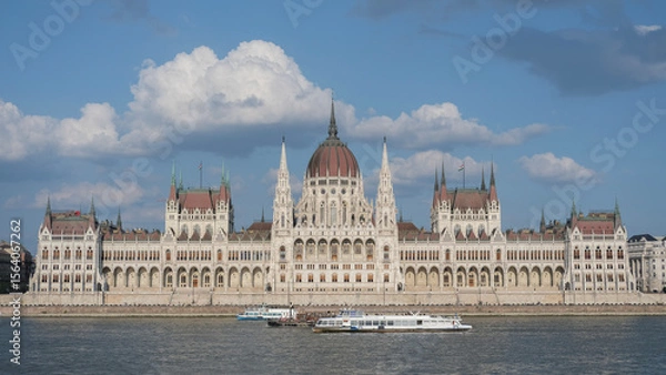 Fototapeta The Hungarian Parliament building during the day, with its majestic architecture and intricate design, set against a clear blue sky.