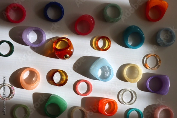 Obraz Collection of colorful plastic rings on white background. Top view.