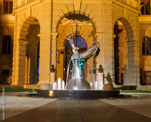 Fototapeta Modern fountain sculpture in front of University of Ljubljana at night
