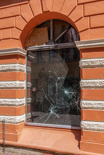 Obraz A damaged window on the ground floor of a building with an orange facade and white decor