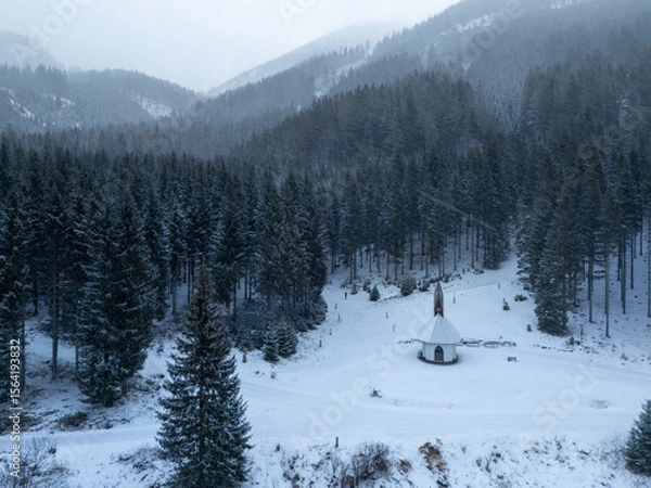 Obraz winter landscape in the mountains in austria drone view and cute chapel in snow