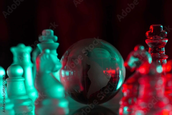 Fototapeta Crystal planet Earth amidst chess pieces showing the American continent, representing concepts of geopolitics, global power, competition for control, international relations, world leaders, struggle f