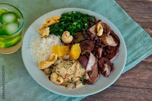Fototapeta The best traditional Brazilian feijoada completely served in the most authentic style accompanied by the irresistible and iconic cachaça caipirinha