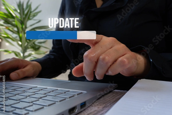 Fototapeta Businesswoman in front of a computer pointing at a bar that counts the percentage of update progress