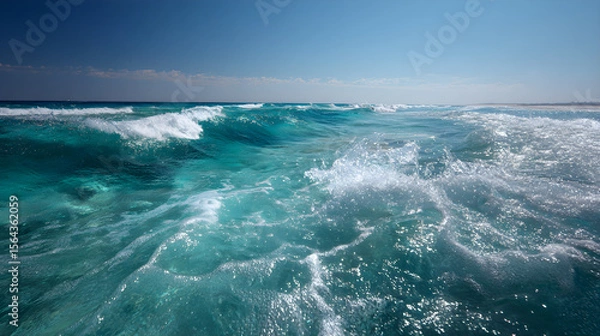 Fototapeta Infinite Turquoise: Capturing the Mesmerizing Dance of Ocean Waves Under Azure Skies with Shimmering Sunlit Crests