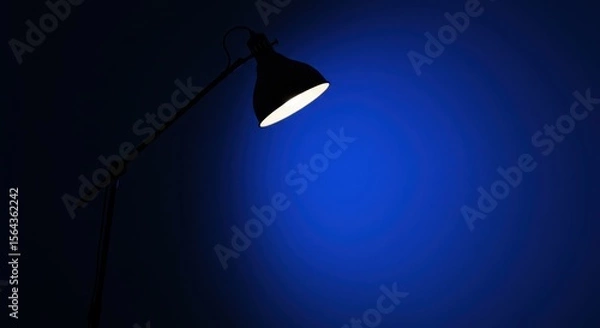 Fototapeta A sleek, modern lamp illuminating a vibrant blue background, creating a calm and artistic atmosphere