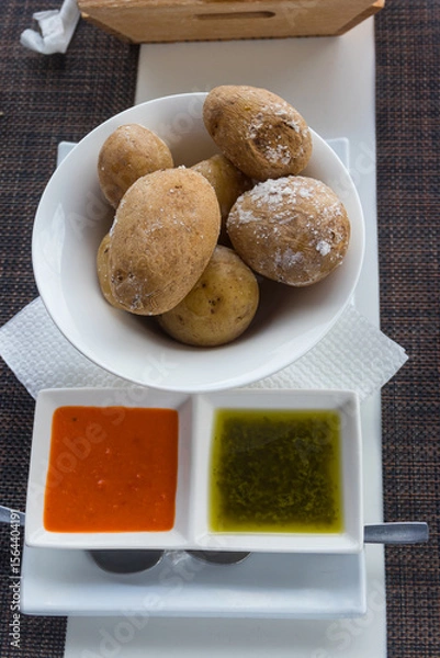 Obraz Portion of canarian potatoes (papas arrugadas) with red and green mojo sauce. Typical dish of the Canary Islands