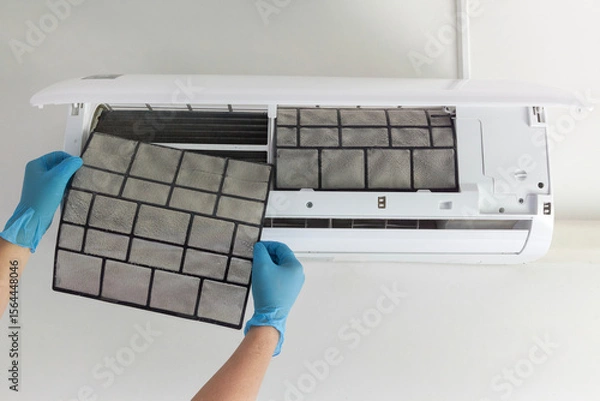 Fototapeta A technician's hand holds a air conditioner filter dusty. preparation for maintenance and cleaning.