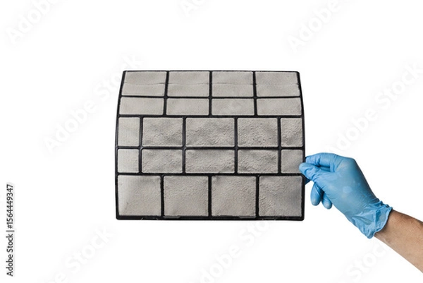 Fototapeta A technician's hand holds a air conditioner filter dusty isolated with clipping path on white background. preparation for maintenance and cleaning.