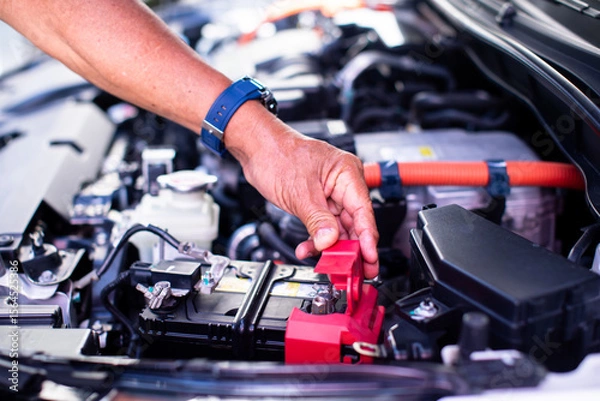 Fototapeta Mechanic's hands are checking engine equipment EV engine car. EV engine car engine block under hood electric vehicle high power and environmentally .