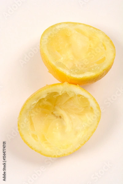Obraz Two squeezed lemon halves on a white background