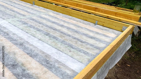 Fototapeta Wooden beams frame a freshly laid vapor barrier, evoking the magic of construction's silent groundwork, akin to Archtobers architectural celebration