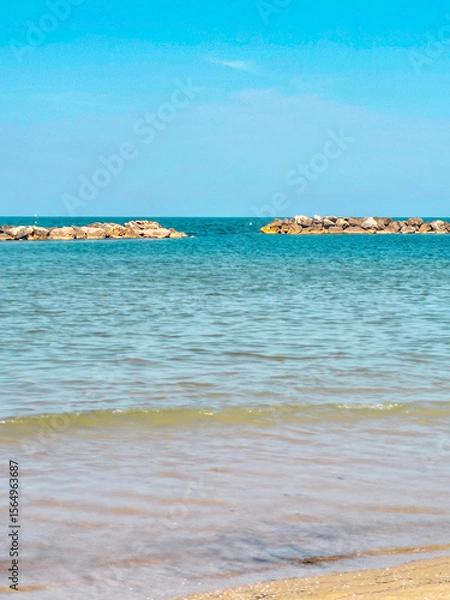 Fototapeta Panoramic view of beach, sea and sand in the summer sun. In the background, a beach area