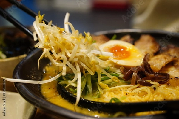 Obraz Close-up of Japanese Ramen Noodles with Chashu Pork, Soft-Boiled Egg, and Bean Sprouts in a Black Bowl