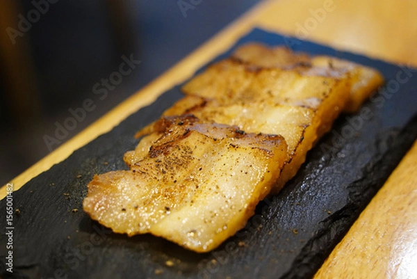 Obraz Close-up of Sliced Seasoned Pork Belly on Slate Plate
