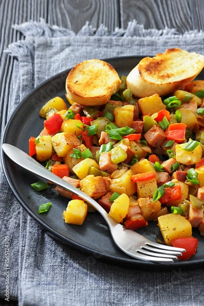 Fototapeta crispy fried cubed potatoes with ham, bell peppers