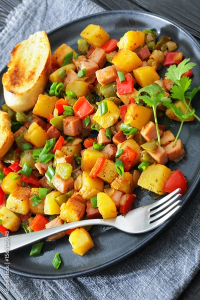 Fototapeta crispy fried cubed potatoes with ham, bell peppers