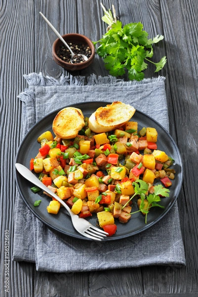 Fototapeta crispy fried cubed potatoes with ham, bell peppers