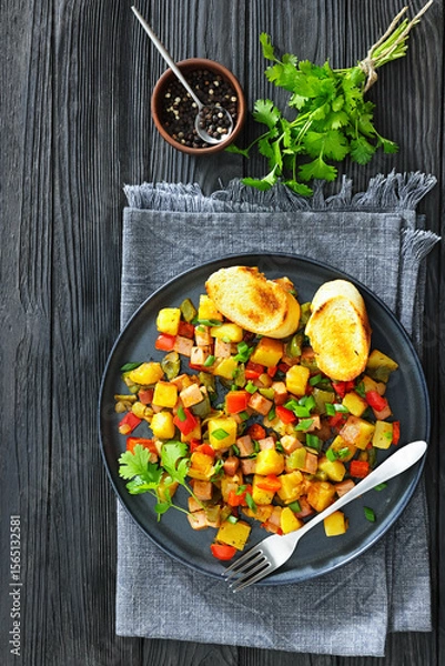Fototapeta crispy fried cubed potatoes with ham, bell peppers