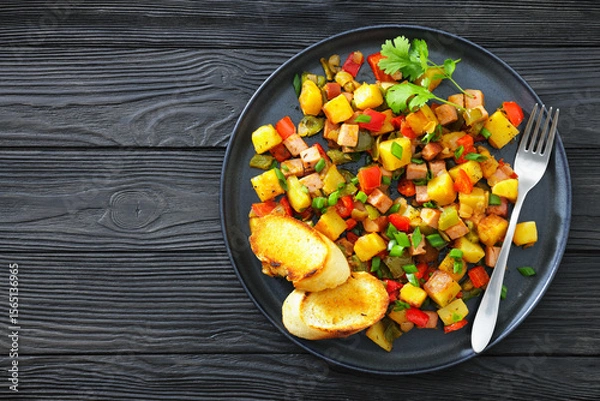 Fototapeta crispy fried cubed potatoes with ham, bell peppers
