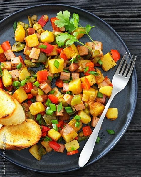 Fototapeta crispy fried cubed potatoes with ham, bell peppers