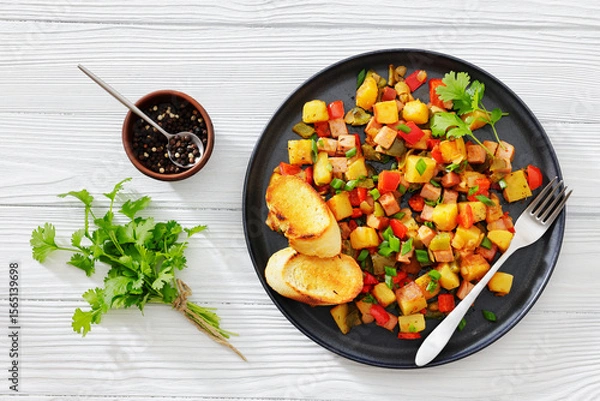 Fototapeta crispy fried cubed potatoes with ham, bell peppers