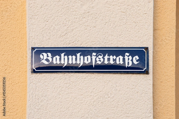 Fototapeta Bahnhofstraße (railway station street) road name sign in Germany. Signage in German language with old letters. Guiding in the direction of the train station in the city or town.