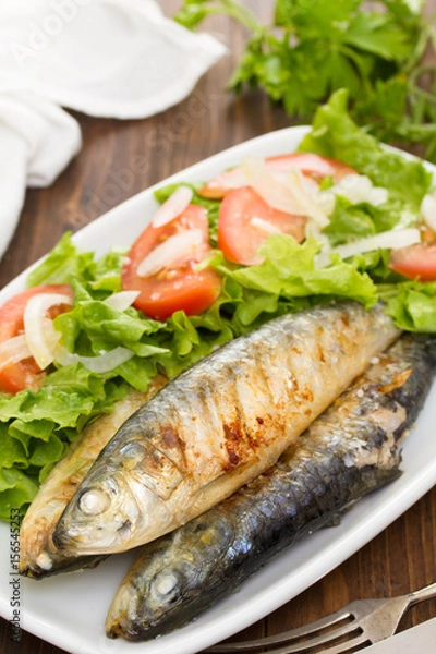 Fototapeta grilled sardines with salad on white dish
