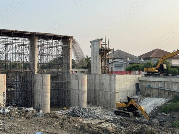 Fototapeta Dam construction site with concrete structure and excavators