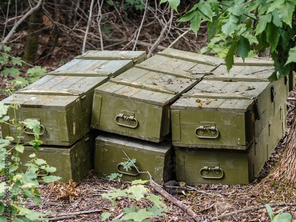 Fototapeta stack of wooden ammunition boxes in the forest