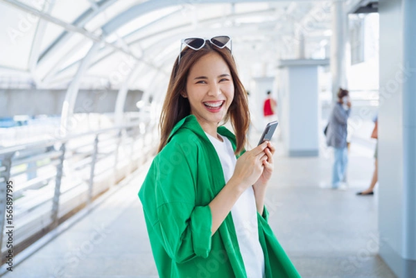 Fototapeta Woman using smartphone in public areas, During leisure time. The concept of using the phone is essential in everyday life.