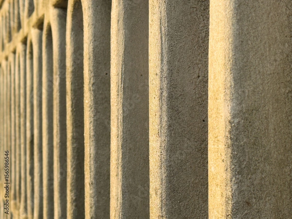 Fototapeta Close-up of textured stone wall with repeating patterns in sunlight
