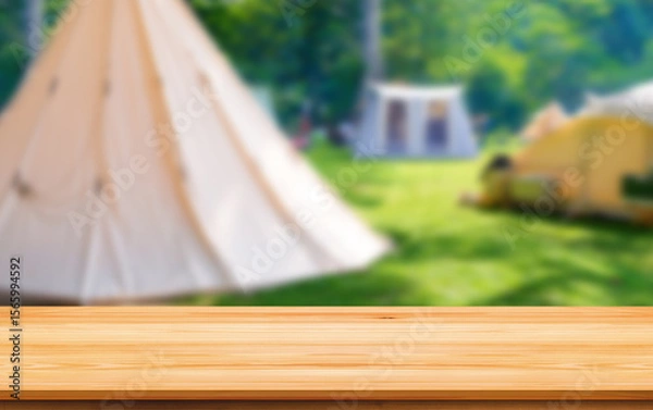 Fototapeta Empty wooden table on blurred background of camping tents in campground area at nature park for montage mockup product display in relaxing activity and recreation on natural traveling concept