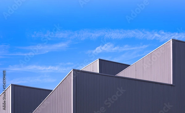 Fototapeta Factory Warehouse Industry Building Background, Architecture Exterior Geometric Metal Wall of Modern Gray Aluminum Rooftop with Blue Sky in Minimal Design, Perspective Low angle view