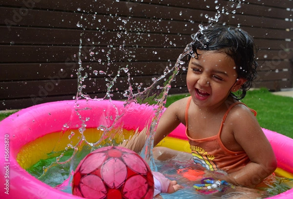 Obraz A girl enjoying in a water pool on a hot summer day!