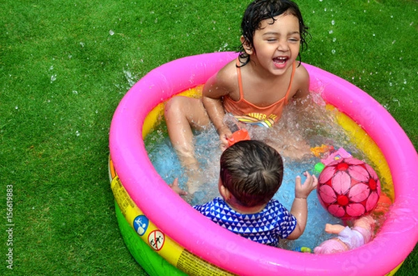 Fototapeta Siostry bawią się i bawią w małym basenie