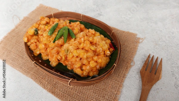 Obraz Perkedel Jagung or Bakwan Jagung, corn fritters is Indonesian traditional food. Savory snack made of corn, egg, flour, spring onion, pepper and salt. Served in wicker bamboo plate on grey background