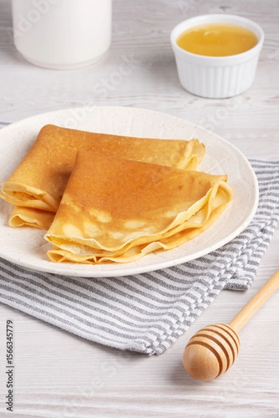 Obraz Traditional Russian pancakes with honey on a white wooden table