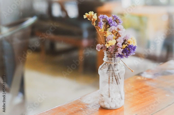 Obraz the flower in the bottle on the wooden floor with dramatic tone